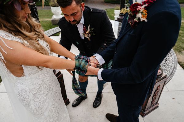 Bride and groom officiant at the alter ribbon