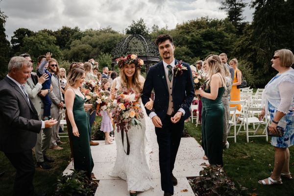 Bride and groom exit ceremony guests clap