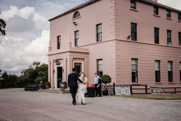 Bride and groom approach wedding venue