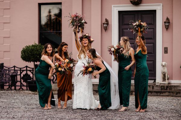 Flowers in the air bridesmaids laughing cheering on