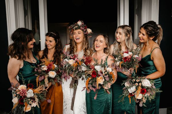 Bride and bridesmaids flowers in hands at door entrance