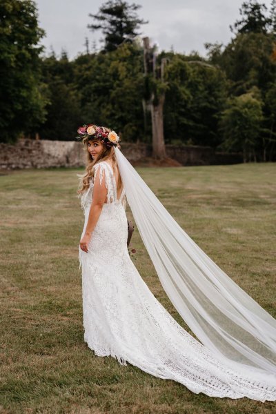 bride with roses flowers in her hair on grass dress detail veil