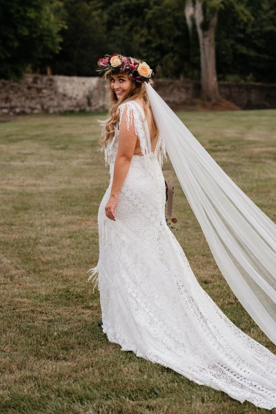 bride with roses flowers in her hair on grass dress detail veil