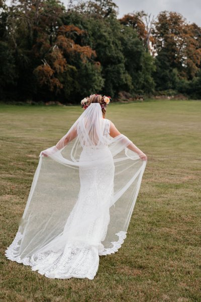 bride with roses flowers in her hair on grass dress detail veil