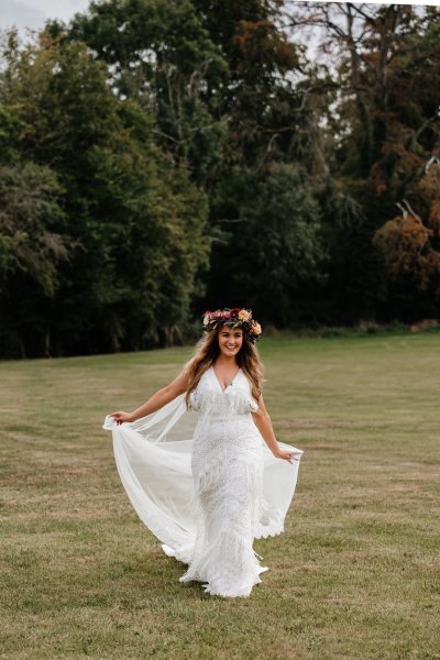 bride with roses flowers in her hair on grass dress detail