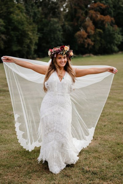 bride with roses flowers in her hair on grass dress detail