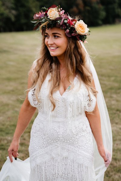 bride with roses flowers in her hair on grass