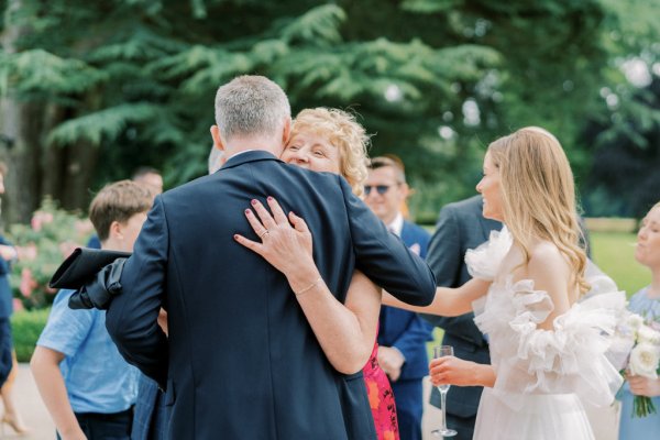 Groom hugs mother/family