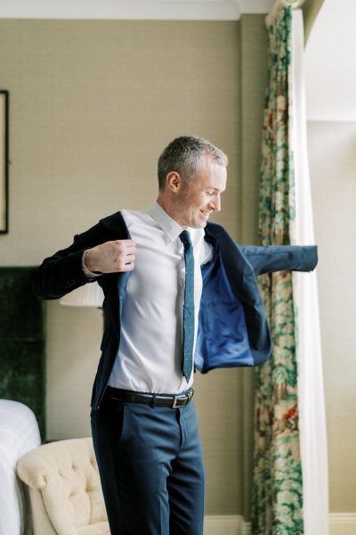 Groom puts on shirt suit jacket