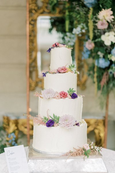 Detail of white wedding cake covered in flowers