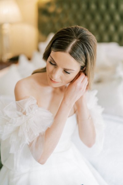 Bride putting on pearl earrings