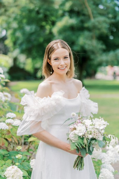 Bride on her own holding white bouquet/flowers