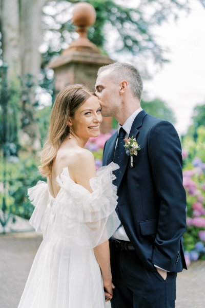 Groom kisses bride on forehead/cheek