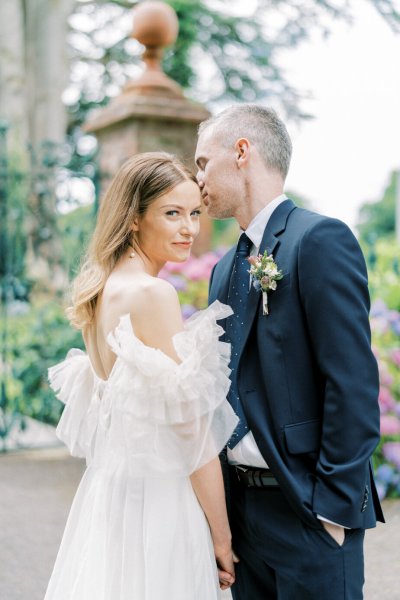 Groom kisses bride on forehead/cheek