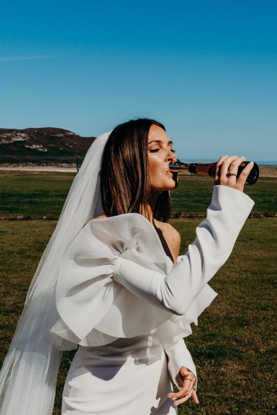 Bride drinks from the bottle champagne or prosecco