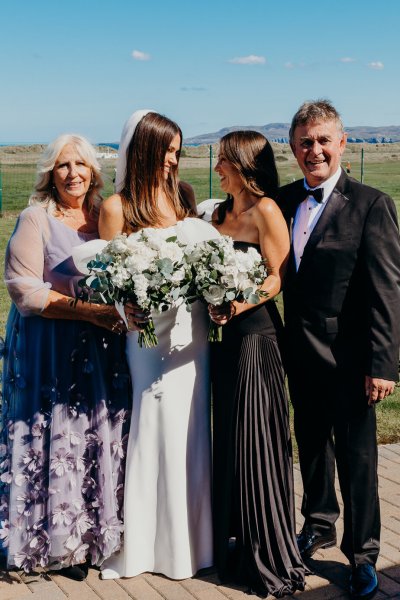 Bride sister bridesmaid father and mother flowers