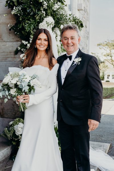 Bride and father pose for camera