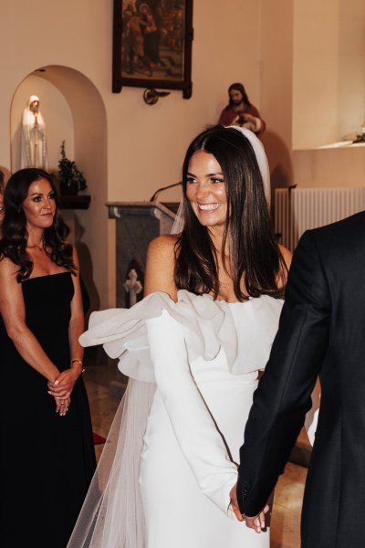 Bride smiling holding grooms hand