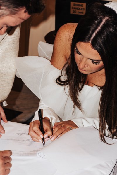 Bride signing marriage cert