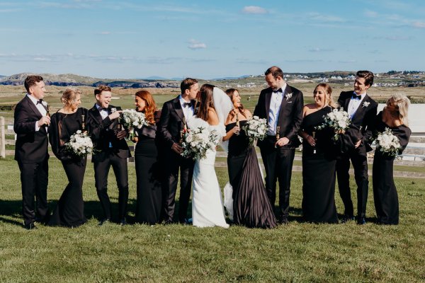 Bride groomsmen flowers bridesmaids wearing black