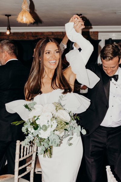 Bride laughing holding flowers smiling