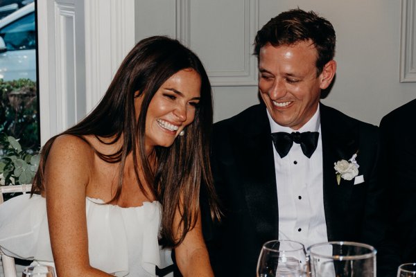 Bride and groom laugh and smile at the table