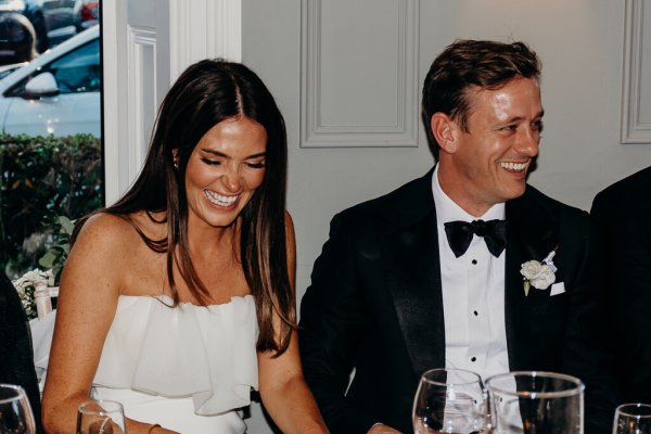 Bride and groom laugh and smile at the table