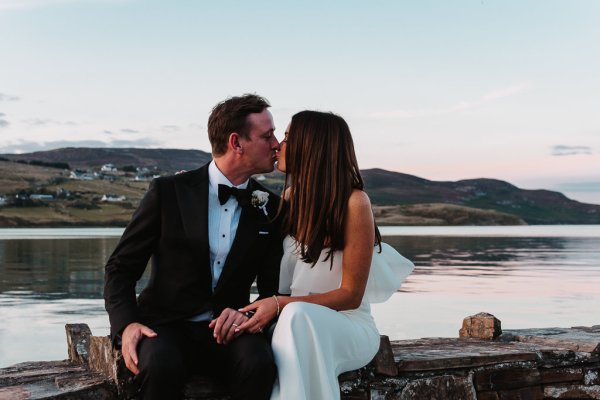 Scenic background lake ocean view with bride and groom kissing