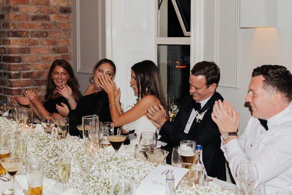 Bride clapping at table