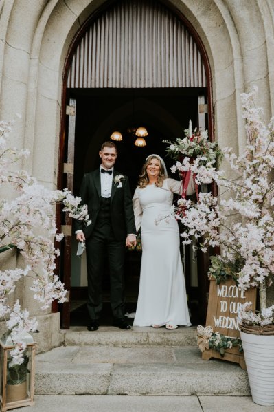 Bride and groom exit church celebrating