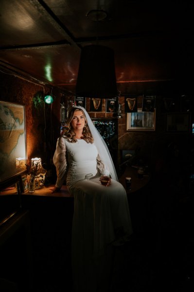 Bride and groom in pub holding pint of Guinness