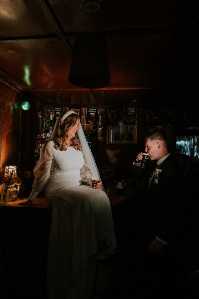 Bride and groom in pub holding pint of Guinness