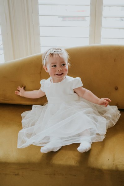 Little girl sitting on yellow couch sofa