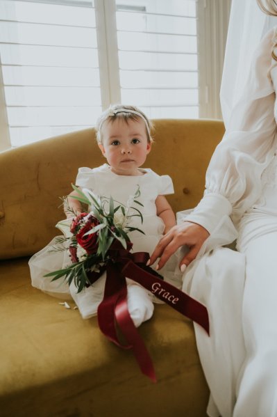 Little girl sitting on yellow couch sofa flowers