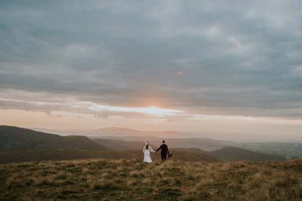 Bride and groom on mountain landscape lake and fog rocks sky view