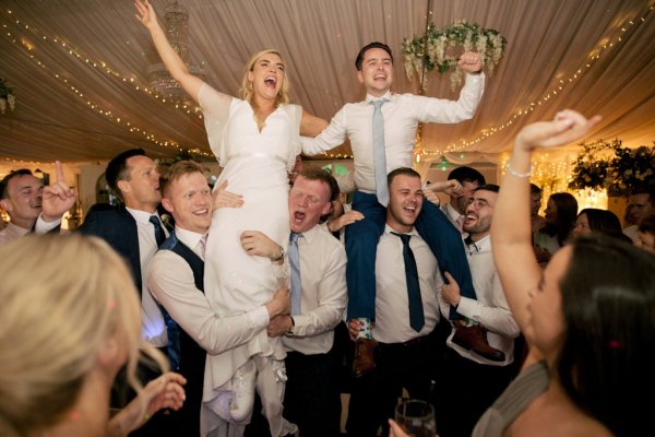 Bride and groom celebrating dancing with guests