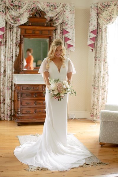 Bride holding bouquet of flowers interior room shot