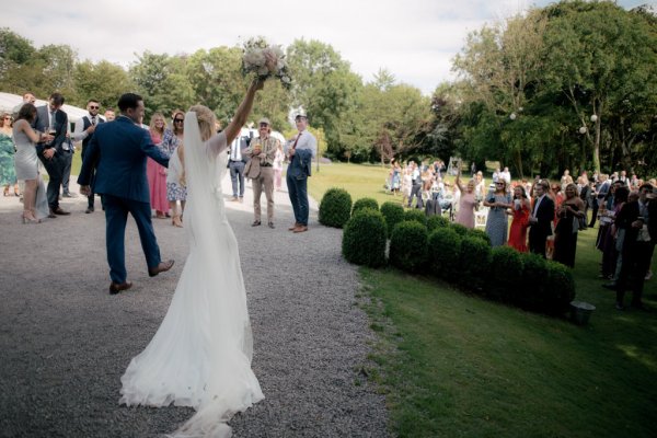 Bride and groom exit ceremony flowers in the air