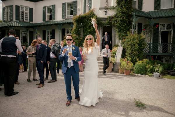 Bride and groom wearing sunglasses cheering