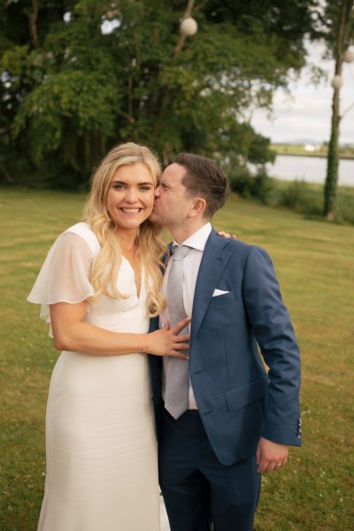 Groom kisses bride on the cheek