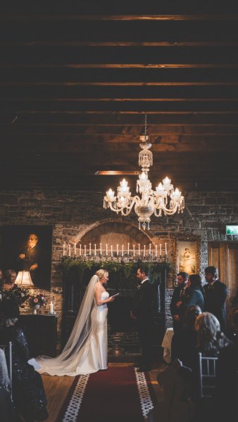 Chandelier hanging above groom and bride