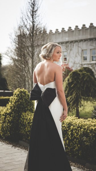 Black bow detail long white bridal dress exterior shot