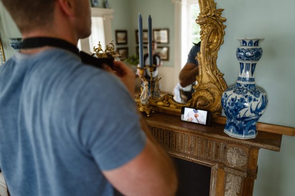 Groom putting on tie camera selfie