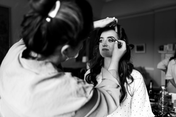 Close up detail of bride getting hair done hairstylist black and white MUA makeup artist