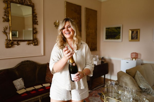 Bridesmaid pops the champagne/prosecco