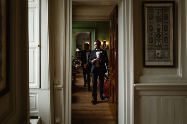 Interior shot of groom walking