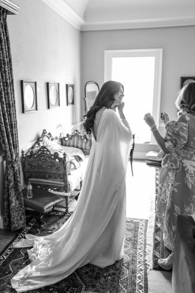 Black and white bridal dress bride putting on earrings