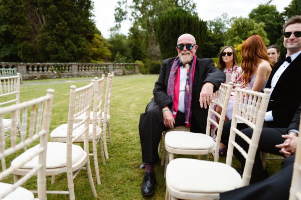 Older gentleman wearing sunglasses sitting seated