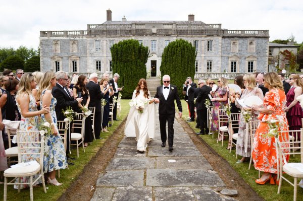 Father of the bride walks down the aisle wearing sunglasses