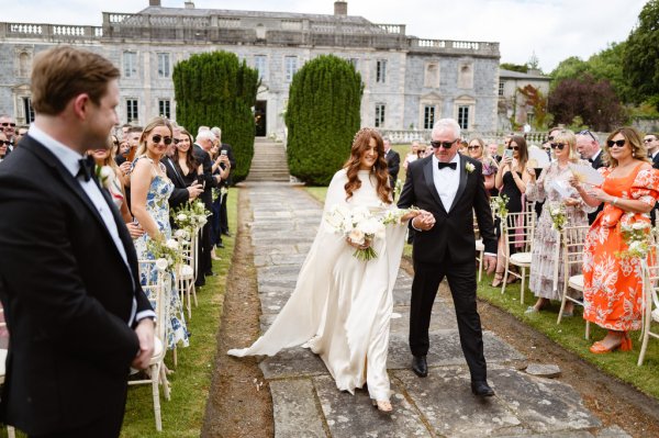 Father of the bride walks down the aisle wearing sunglasses